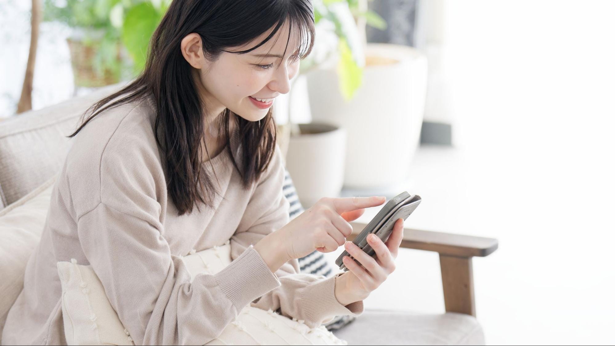 笑顔でスマホを操作する女性